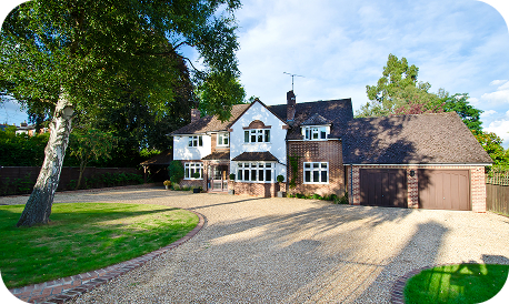 Front view of a big house with a garage and a drive.